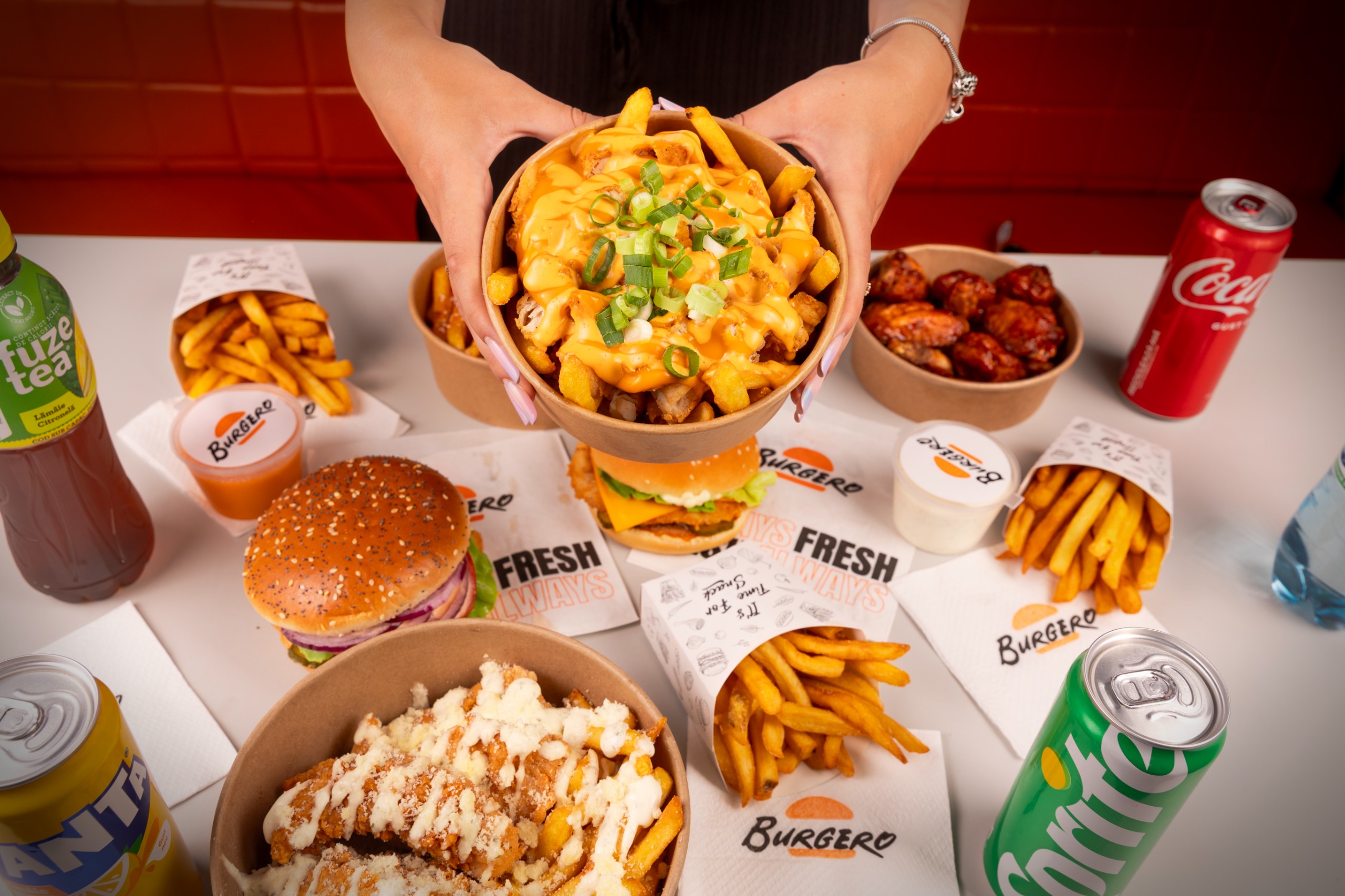 Loaded fries Burgero cu sos de brânză și ceapă verde, alături de burgeri și aripioare